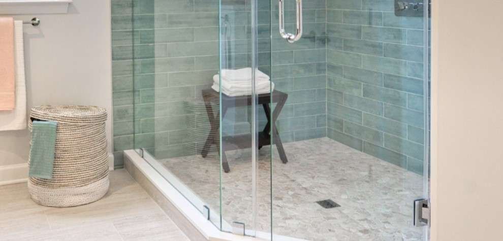 Modern glass shower with teal tile walls.