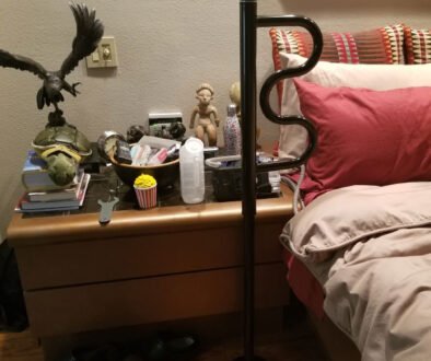 Cozy bedroom scene with various items on nightstand.