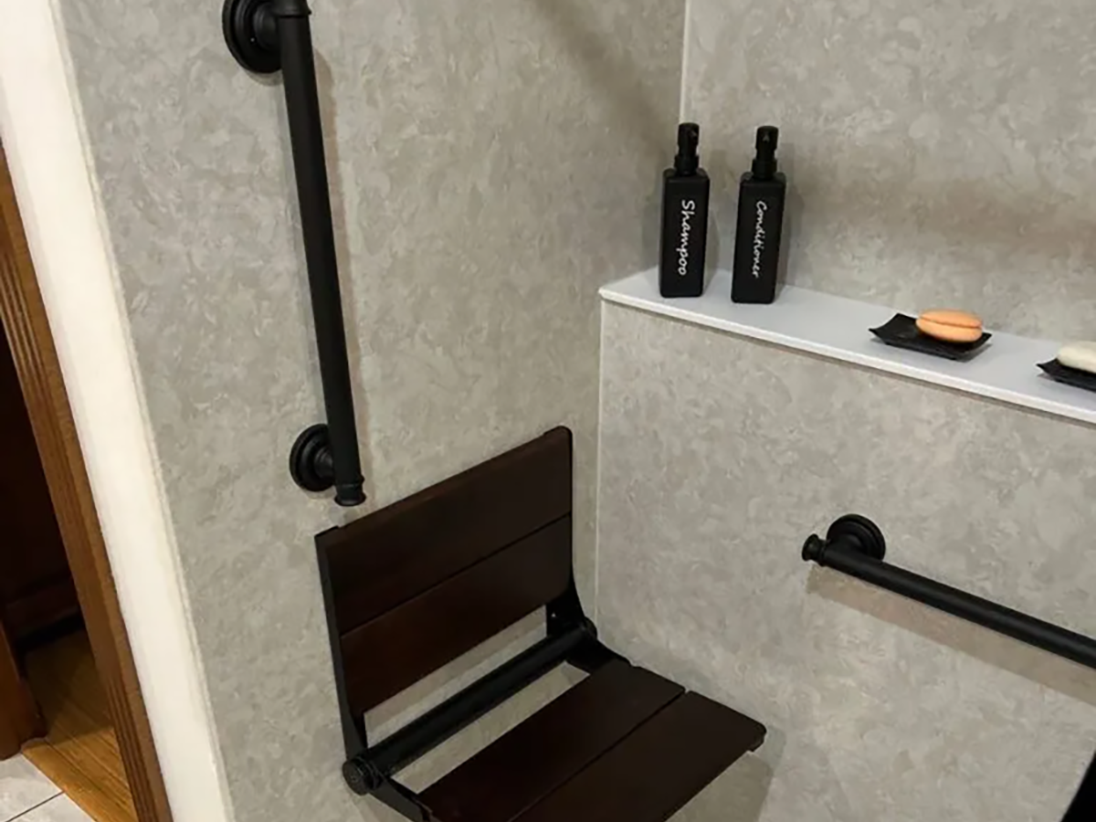 Accessible shower with grab bars and bench seating.