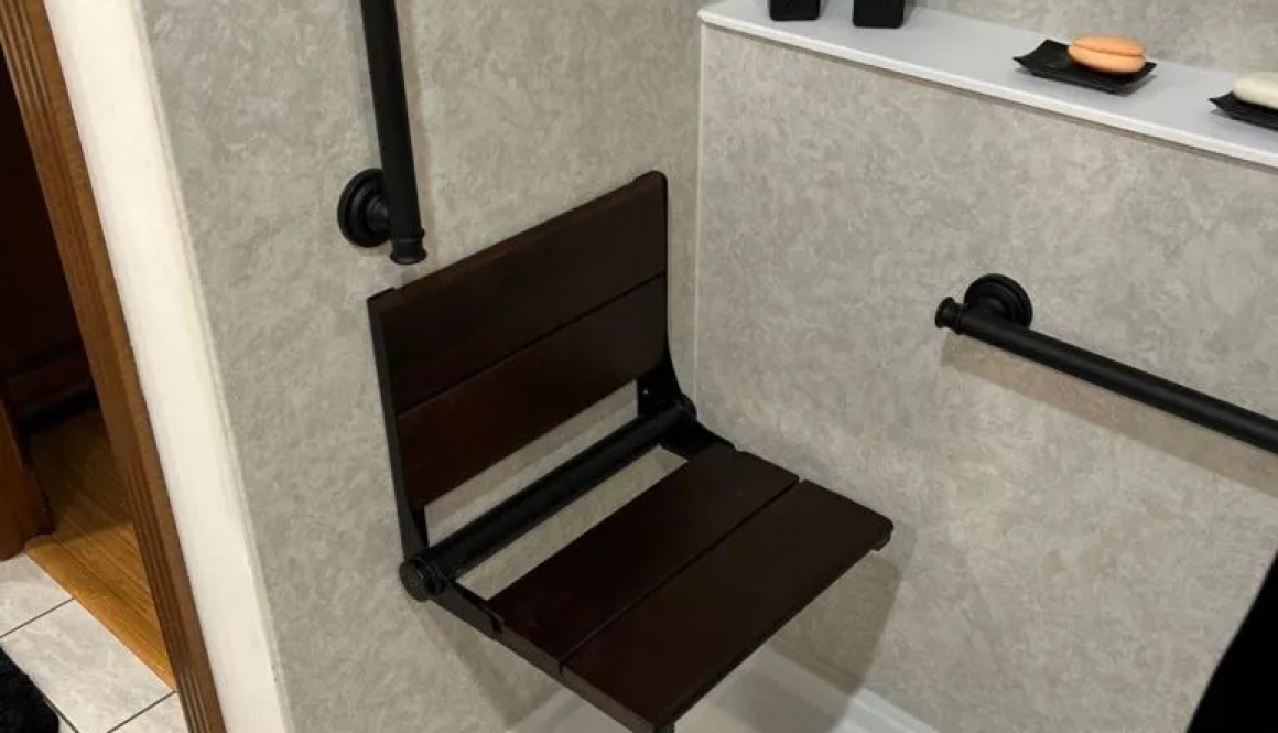 Accessible shower with foldable seat and grab bars.
