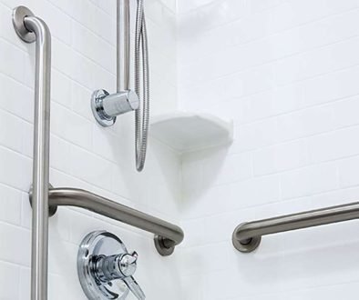 Accessible shower with grab bars and handheld showerhead.