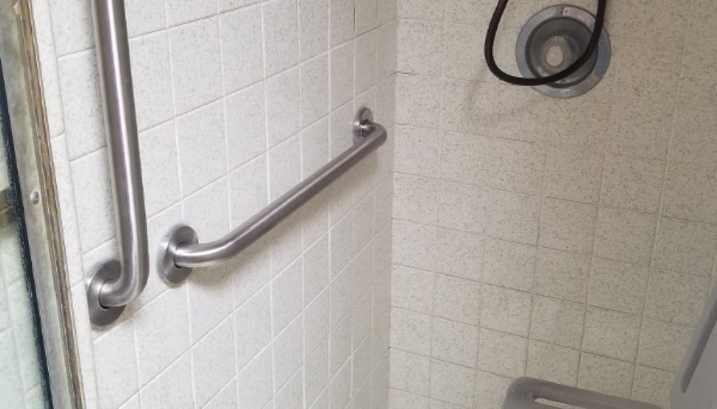 Accessible shower with grab bars and seat.