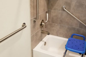Three Grab Bars Installed In Bathroom Shower With Blue Shower Chair