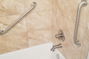 Two Stainless Steel Grab Bars Installed On Tiled Walls Over Bathtub