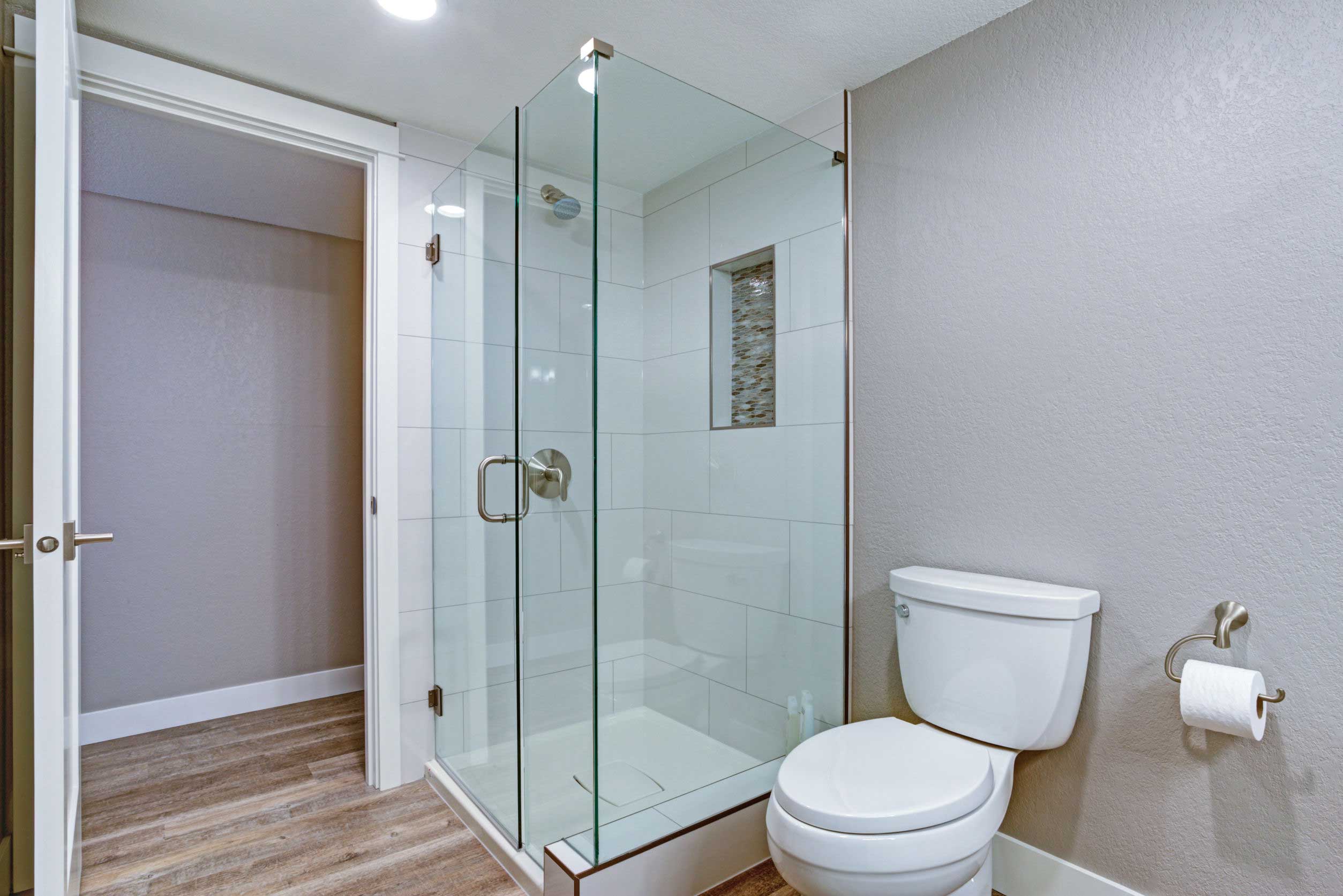 Modern bathroom with glass shower and toilet.